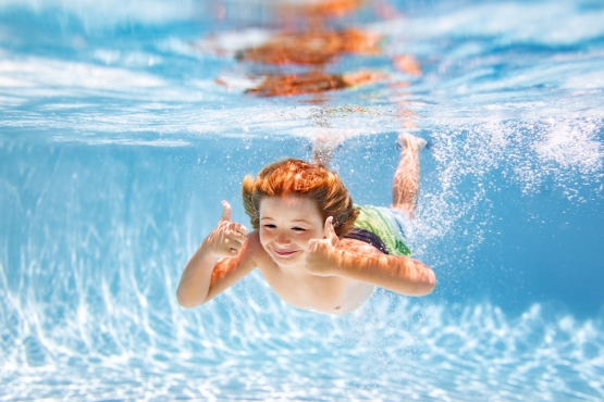 1 child boy swimming underwater in swimming pool funny kids boy play and swim in the sea water