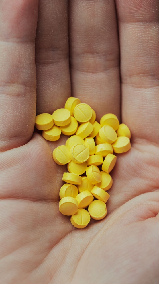 1 woman with a handful of yellow pills