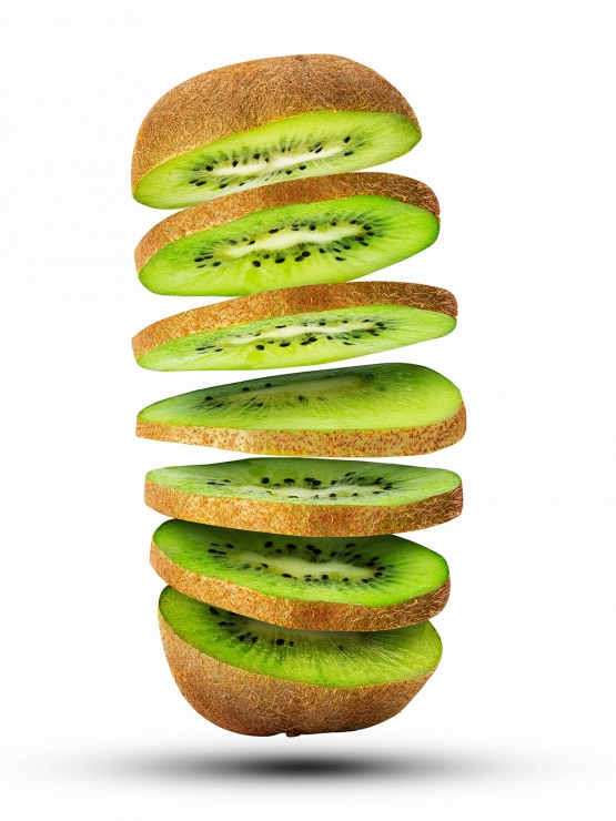fresh sliced kiwi fruit flying in the air isolated on white