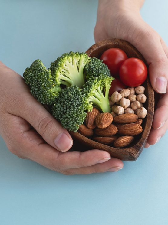 hands holding a healthy food heart shaped wood on blue background