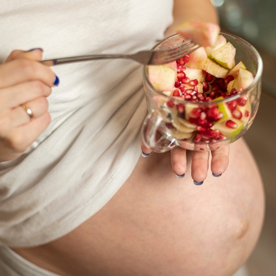 mani della donna incinta che tengono un insalata saporita