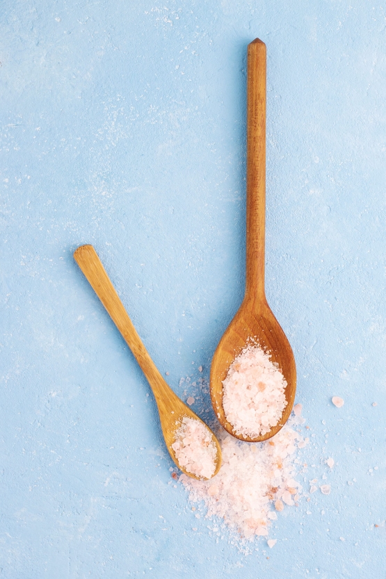 wooden spoons with pink himalayan salt blue background